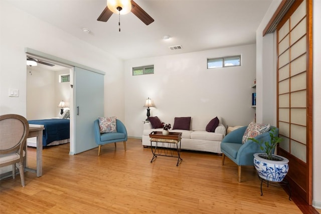 sitting room featuring light wood-style flooring, visible vents, and ceiling fan