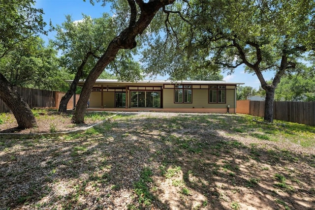 rear view of house featuring fence