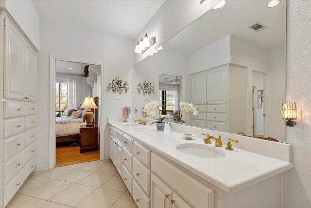 full bath with tile patterned floors, connected bathroom, visible vents, and a sink