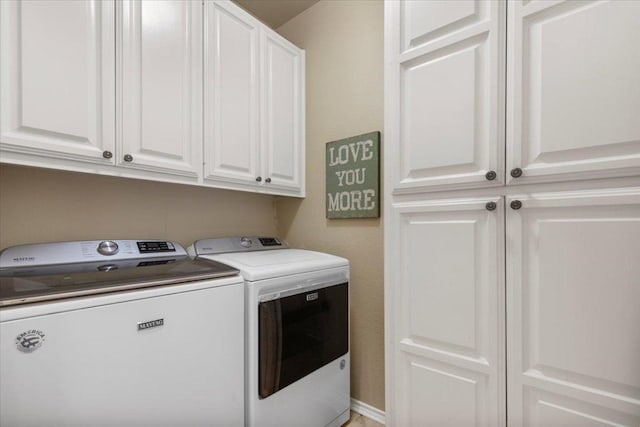 clothes washing area featuring cabinet space and separate washer and dryer