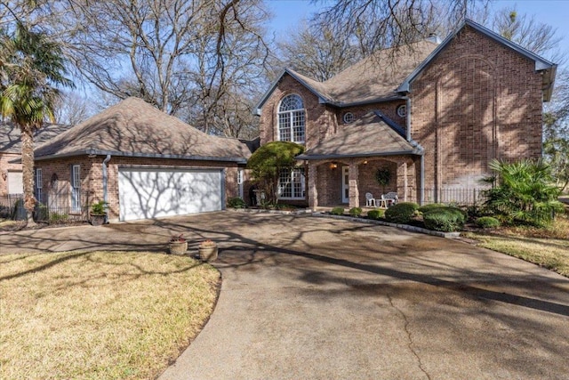 view of front facade with a front lawn, an attached garage, brick siding, and driveway