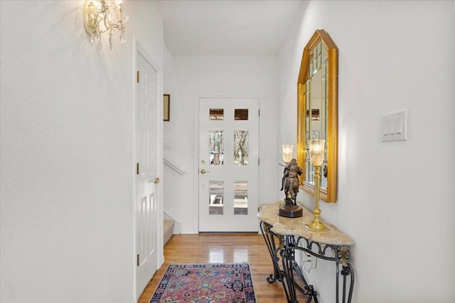 entryway featuring light wood-style flooring and a chandelier