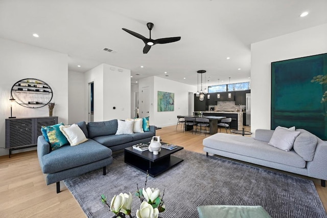 living area featuring a ceiling fan, recessed lighting, visible vents, and light wood finished floors