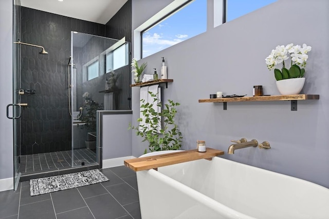 bathroom with tile patterned floors, a freestanding tub, and a stall shower