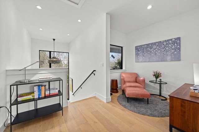 sitting room featuring an upstairs landing, recessed lighting, baseboards, and wood finished floors