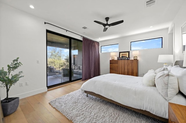 bedroom featuring access to outside, multiple windows, wood finished floors, and visible vents