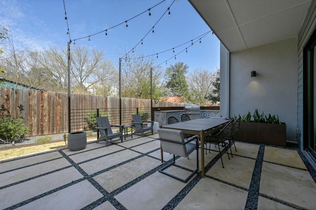 view of patio featuring outdoor dining area, a grill, and fence