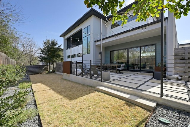 rear view of property featuring a fenced backyard and a patio area