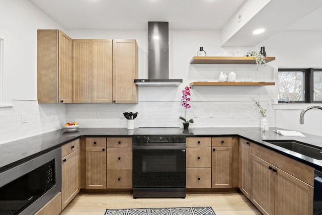 kitchen featuring stainless steel microwave, black range with electric cooktop, wall chimney range hood, decorative backsplash, and a sink