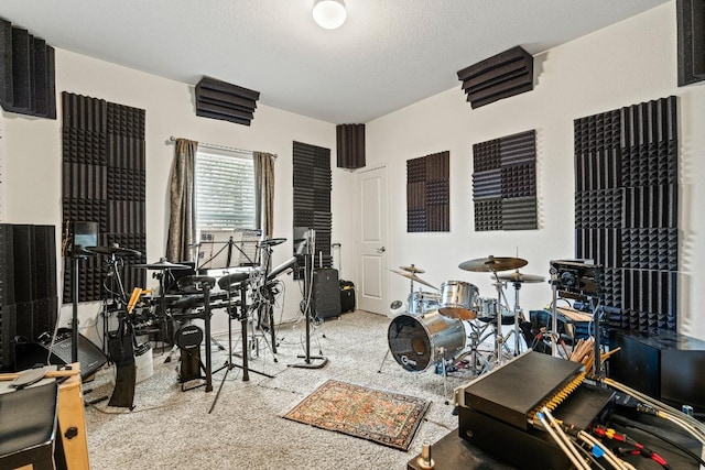 recreation room featuring a textured ceiling and carpet floors
