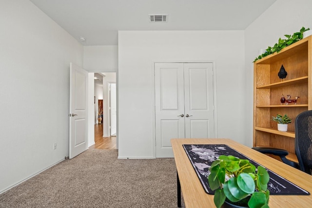 carpeted bedroom with visible vents and a closet