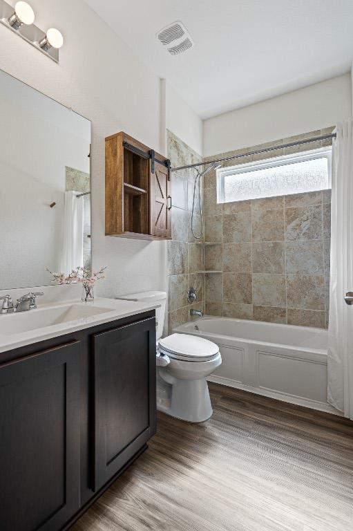 701 Mallow Rd, Leander, TX 78641 - full bath featuring shower / bath combo with shower curtain, vanity, toilet, and wood finished floors