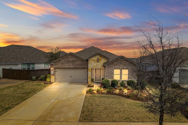 view of front of home featuring a garage, stone siding, brick siding, and driveway