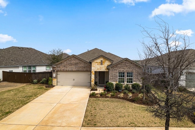 view of front of house featuring an attached garage, fence, brick siding, and stone siding