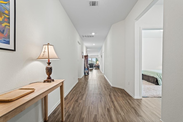 hallway with recessed lighting, wood finished floors, visible vents, and baseboards