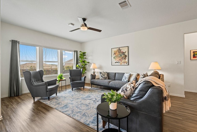 living room with a ceiling fan, wood finished floors, visible vents, and baseboards