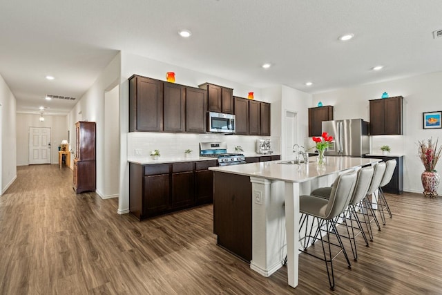 kitchen featuring dark wood-type flooring, visible vents, appliances with stainless steel finishes, and a sink