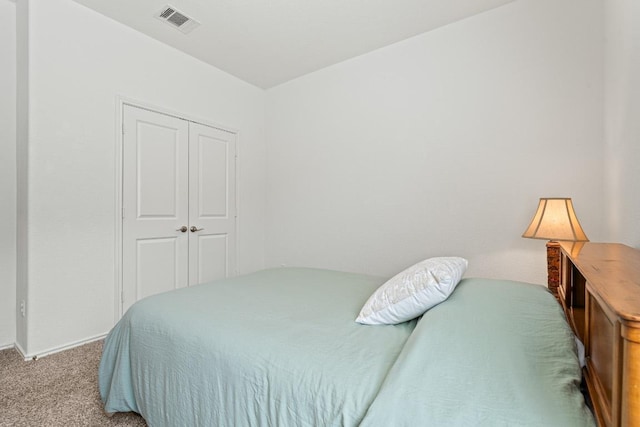 carpeted bedroom featuring visible vents and a closet