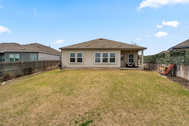 rear view of property with a yard, a patio, a fenced backyard, and stucco siding