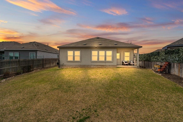 back of house featuring a fenced backyard, a patio area, and a yard