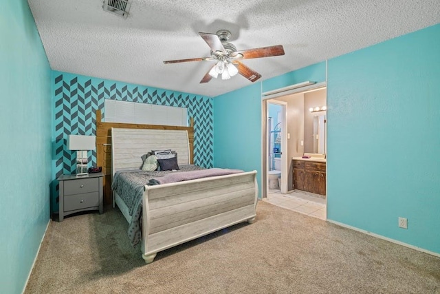 carpeted bedroom featuring visible vents, a textured ceiling, wallpapered walls, and an accent wall