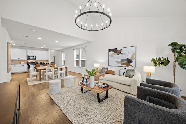 living area featuring recessed lighting, light wood-style floors, and a chandelier