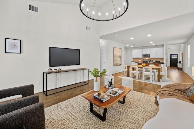 living area with recessed lighting, light wood-style floors, visible vents, and a chandelier