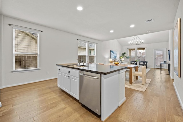 kitchen featuring a sink, stainless steel dishwasher, dark countertops, light wood-type flooring, and a chandelier