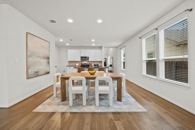 dining room with visible vents, recessed lighting, baseboards, and wood finished floors