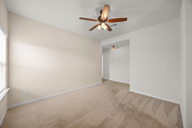 carpeted empty room with visible vents, ceiling fan, and baseboards