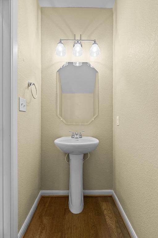 bathroom featuring a sink, baseboards, and wood finished floors