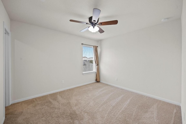 spare room with a ceiling fan, baseboards, and light carpet