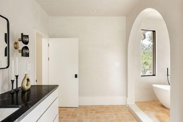 full bath with vanity and a soaking tub