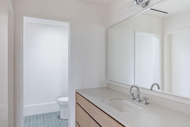 bathroom with vanity, tile patterned floors, toilet, and baseboards