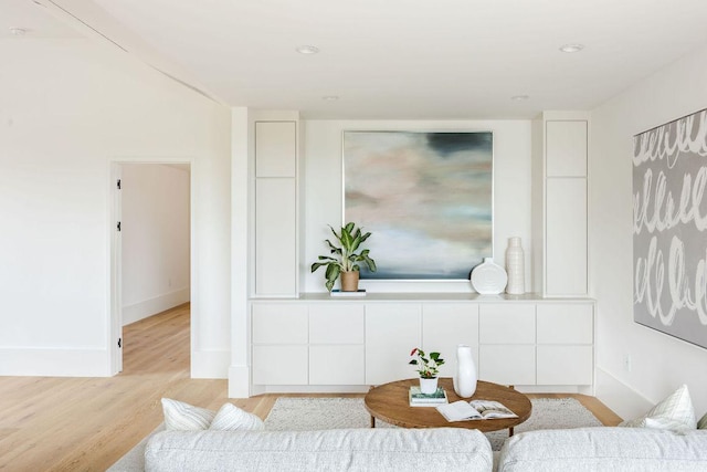 living area with light wood-type flooring and baseboards