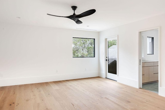 empty room with a ceiling fan, baseboards, and light wood finished floors