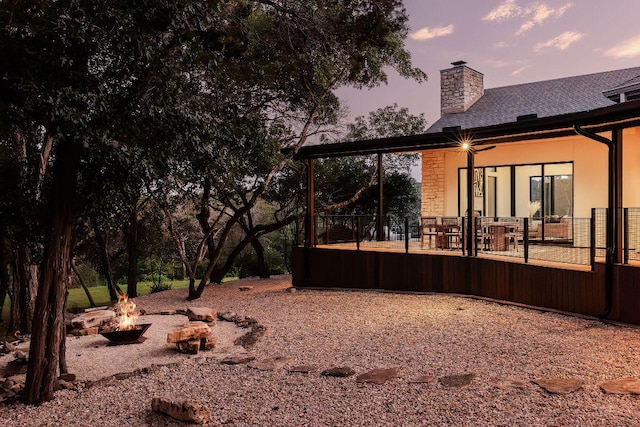 yard at dusk featuring a fire pit