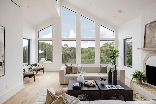 sunroom / solarium with lofted ceiling and a fireplace with raised hearth