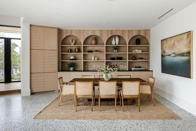 dining area featuring built in shelves and speckled floor