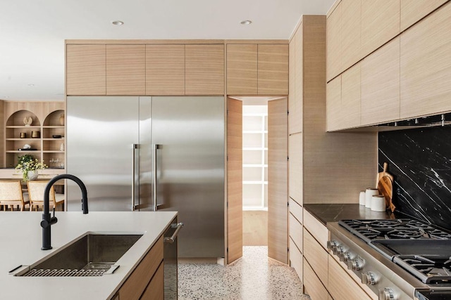 kitchen with a sink, range, backsplash, and modern cabinets