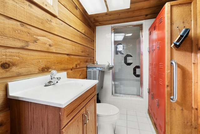 121 Scott St, San Marcos, TX 78666 - bathroom featuring tile patterned flooring, wooden walls, toilet, a shower with shower door, and vanity