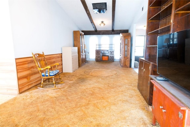 interior space featuring beamed ceiling, light carpet, visible vents, and brown cabinetry