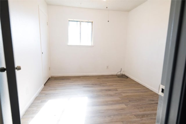 unfurnished room with light wood-style floors and baseboards