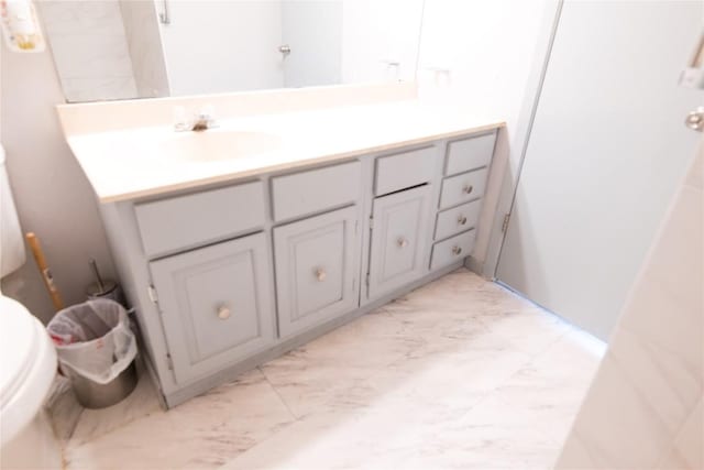 bathroom featuring vanity, toilet, and marble finish floor