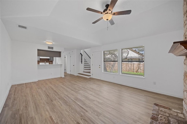 unfurnished living room featuring stairway, light wood-style flooring, visible vents, and baseboards