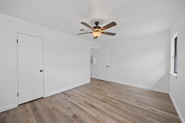 spare room with a ceiling fan, wood finished floors, and baseboards