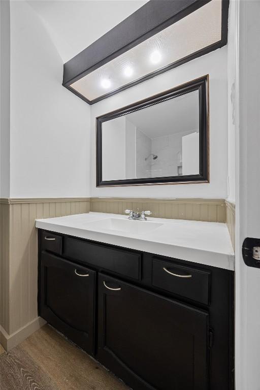 bathroom with wainscoting, vanity, and wood finished floors