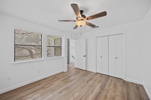 unfurnished bedroom with a closet, visible vents, baseboards, and light wood-style floors