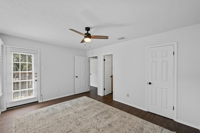 unfurnished bedroom with dark wood-type flooring, access to exterior, baseboards, and visible vents