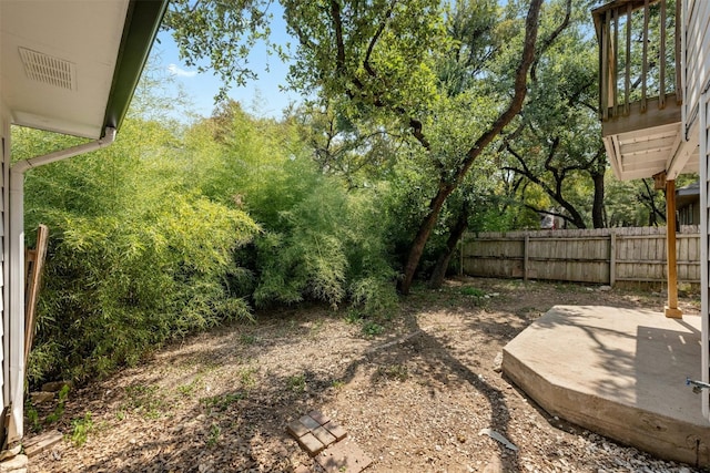 view of yard featuring fence and visible vents